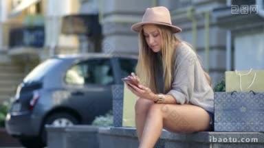 妇女网上购物使用手机户外开朗的妇女坐在户外购物袋和网上购物